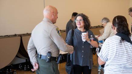 Attendees standing with local officer at the event