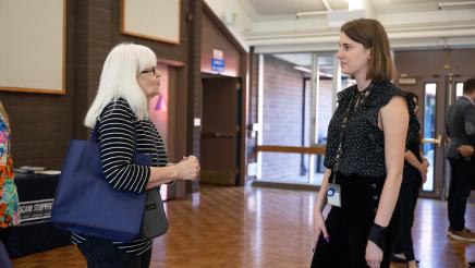 Guest speaker and attendee conversing at the event