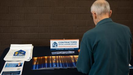 Attendee taking a look at the Contractors State License Board event table