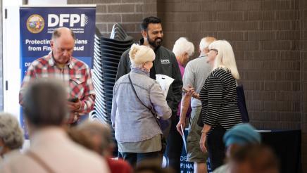 Guest speaker and attendees conversing at the event