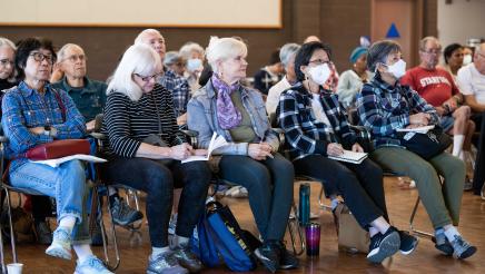 Attendees looking at the event presentation