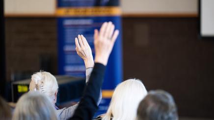 Attendees in the crowd raising their hands up